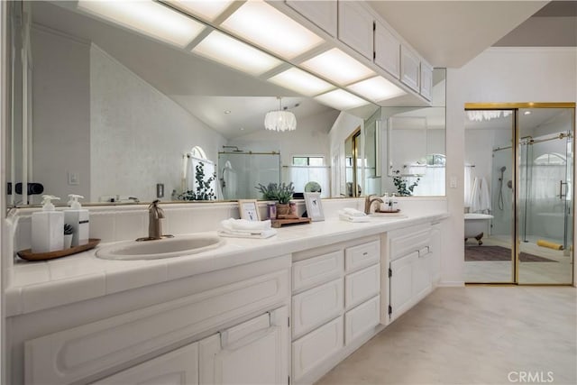full bath with a sink, double vanity, a shower stall, and vaulted ceiling