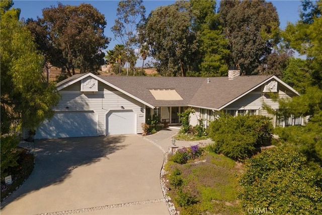 ranch-style house with concrete driveway, a chimney, and a garage
