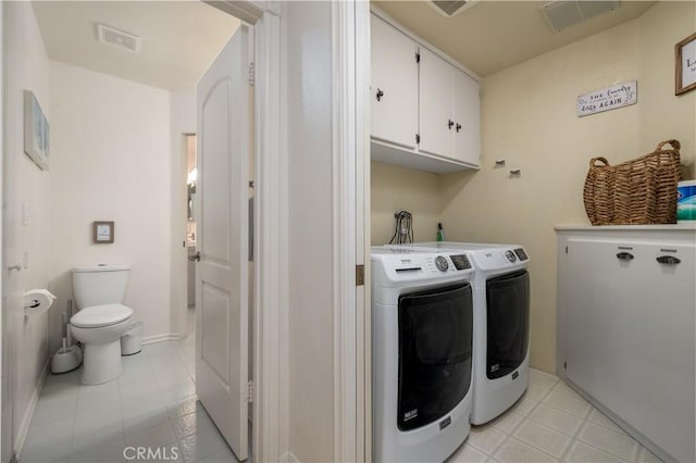 laundry area with light tile patterned floors, visible vents, cabinet space, and washer and clothes dryer