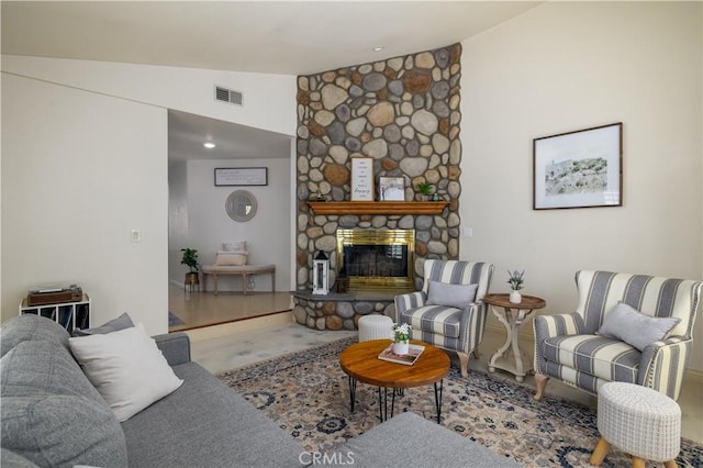 living room with baseboards, a stone fireplace, visible vents, and vaulted ceiling