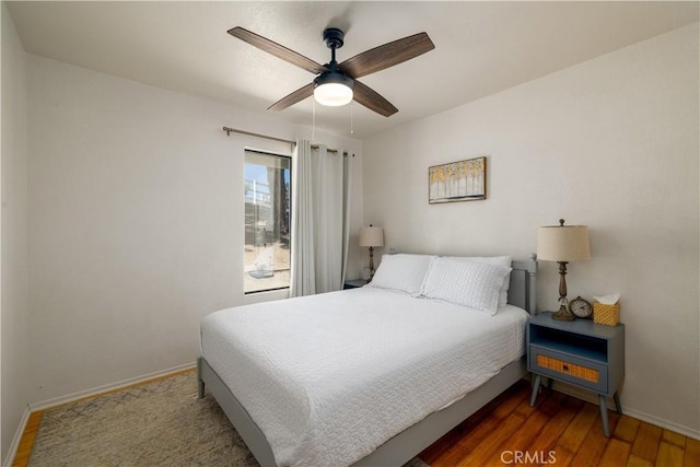 bedroom featuring wood finished floors, baseboards, and ceiling fan