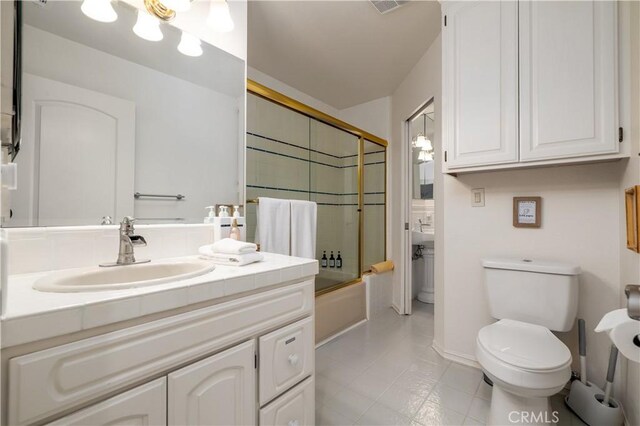 37450 Downey Rd, Temecula, CA 92592 - bathroom with toilet, bath / shower combo with glass door, vanity, tile patterned floors, and baseboards