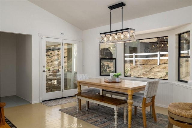 dining area with lofted ceiling, french doors, and wood finished floors