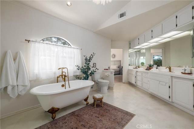 bathroom with double vanity, a sink, a freestanding bath, visible vents, and vaulted ceiling