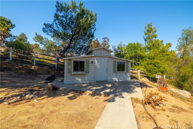 view of outbuilding featuring an outdoor structure and fence