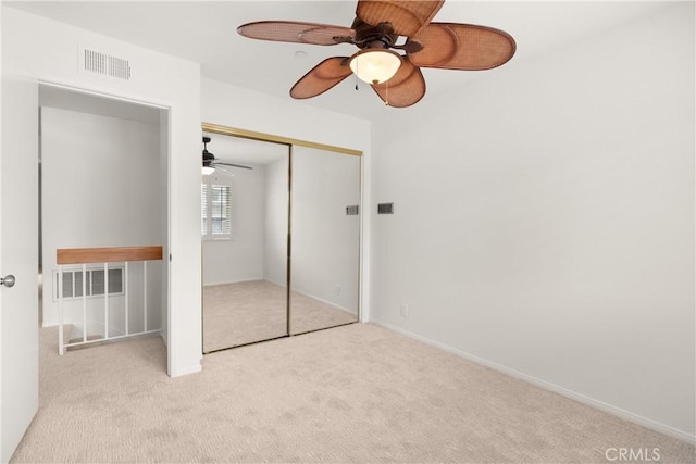 unfurnished bedroom featuring visible vents, carpet floors, a closet, baseboards, and ceiling fan