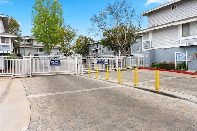 view of road featuring curbs, a gated entry, and a residential view
