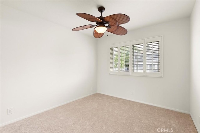 unfurnished room with ceiling fan, light colored carpet, and baseboards