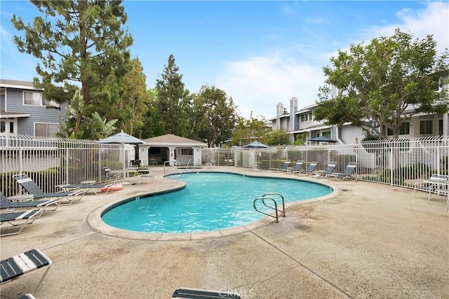 community pool with fence and a patio