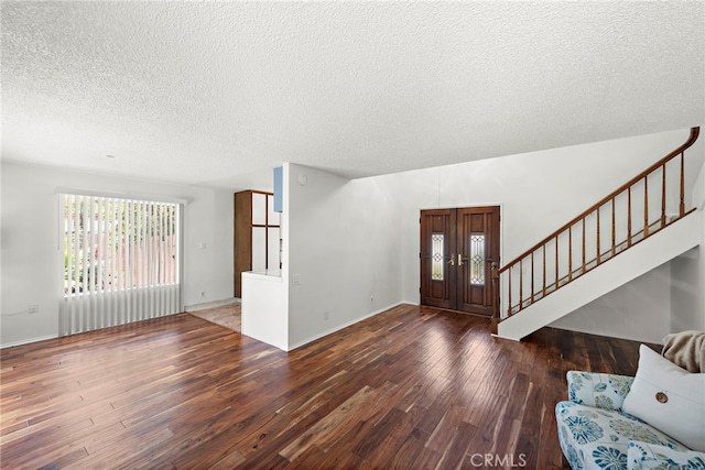 entrance foyer featuring baseboards, a textured ceiling, wood finished floors, and stairway
