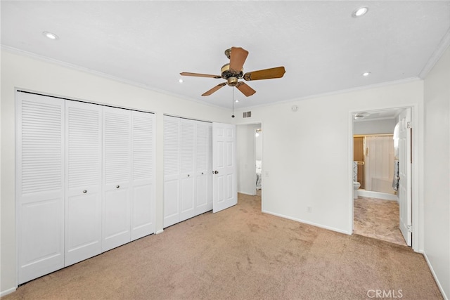 unfurnished bedroom featuring baseboards, two closets, ornamental molding, carpet flooring, and recessed lighting