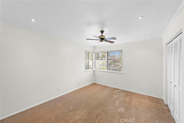 unfurnished bedroom featuring carpet flooring, baseboards, ornamental molding, and a closet