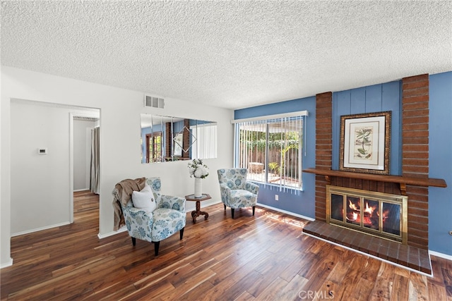 living area featuring a textured ceiling, visible vents, and wood finished floors