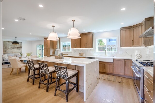 2027 Kornat Dr, Costa Mesa, CA 92626 - kitchen with stainless steel stove, a sink, light wood-style floors, light stone counters, and recessed lighting