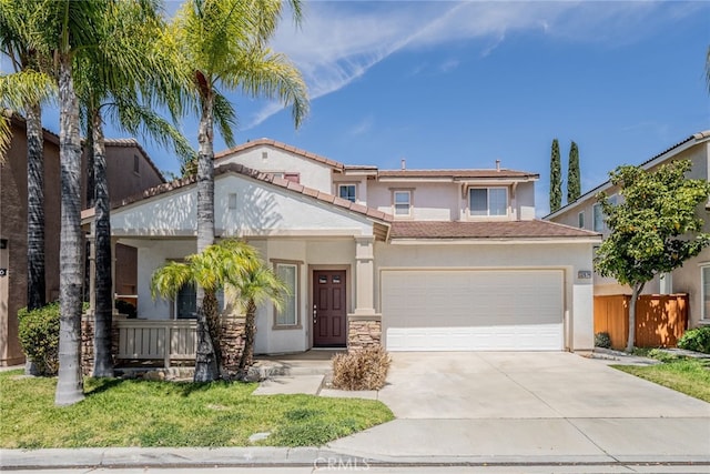 view of front of home with a tiled roof, driveway, fence, an attached garage, and stucco siding