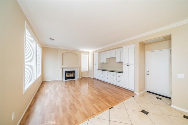 32674 Clearvail Dr, Temecula, CA 92592 - unfurnished living room featuring healthy amount of natural light, baseboards, a fireplace with flush hearth, ornamental molding, and light wood-type flooring