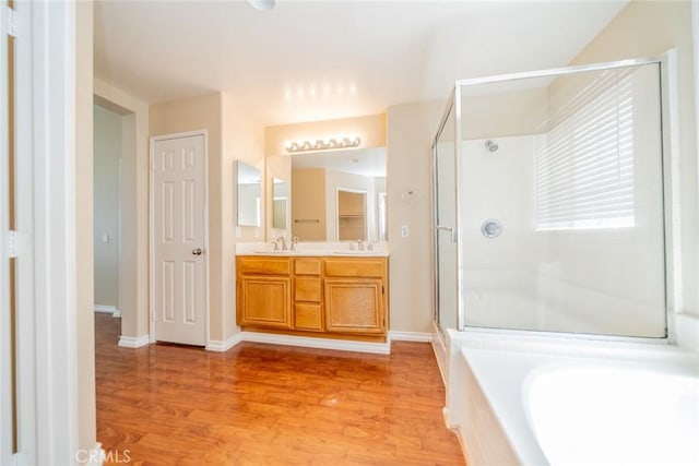 32674 Clearvail Dr, Temecula, CA 92592 - bathroom featuring a shower stall, wood finished floors, double vanity, a garden tub, and baseboards