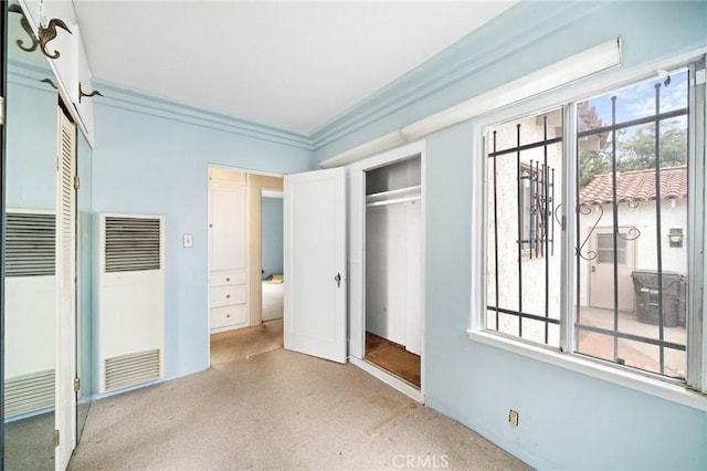 unfurnished bedroom with crown molding and a heating unit