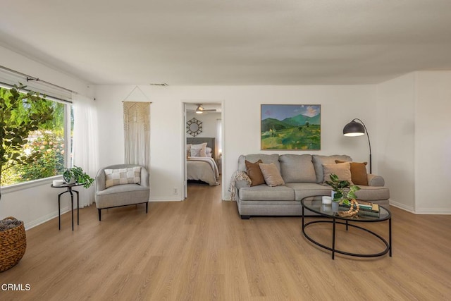 living room with baseboards, light wood finished floors, and visible vents