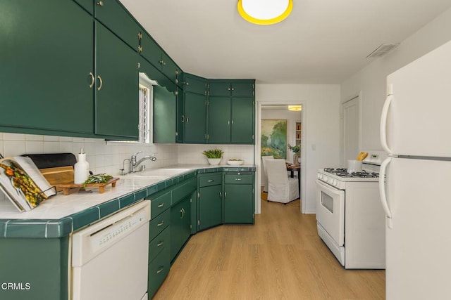 kitchen with backsplash, visible vents, light wood-type flooring, a sink, and white appliances