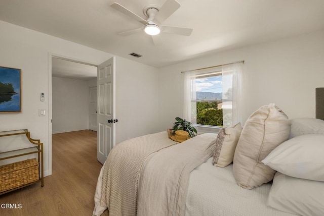 bedroom featuring a ceiling fan, baseboards, visible vents, and light wood-style flooring