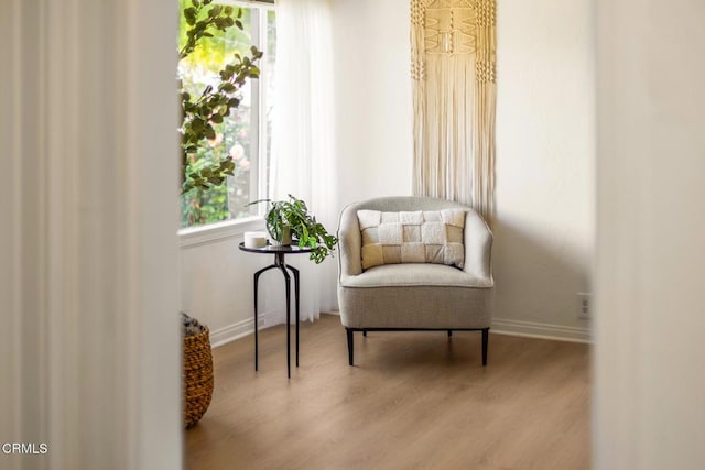 sitting room with baseboards and wood finished floors