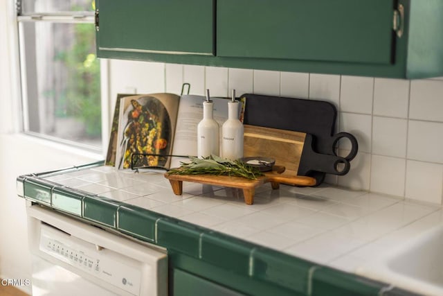 details with decorative backsplash, green cabinetry, and dishwasher