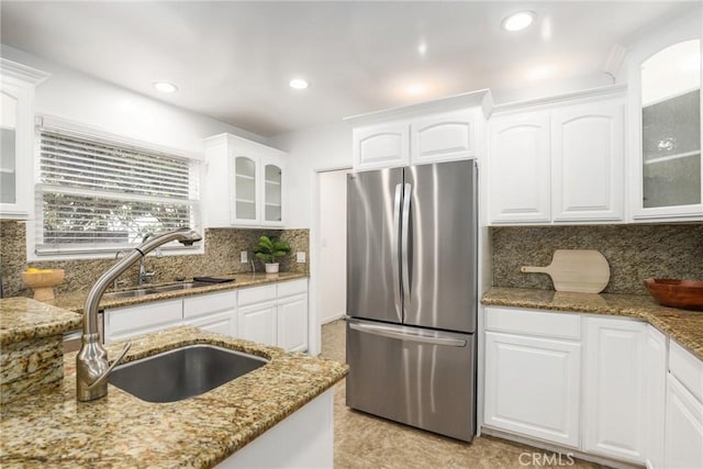 8163 Billowvista Dr, Playa Del Rey, CA 90293 - kitchen featuring white cabinets, light stone countertops, a sink, freestanding refrigerator, and tasteful backsplash