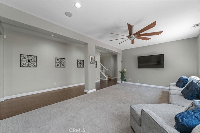 carpeted living area featuring recessed lighting, baseboards, ceiling fan, and stairs