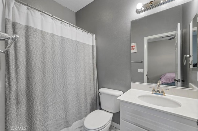 bathroom with vanity, connected bathroom, and toilet