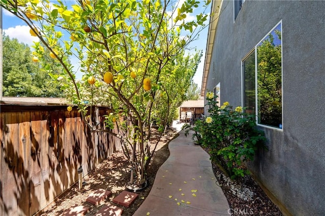 view of property exterior with stucco siding and fence