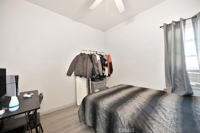 bedroom with ceiling fan, vaulted ceiling, and light wood finished floors