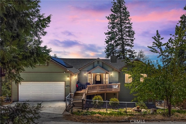6377 Sugar Pines Cir, Angelus Oaks, CA 92305 - view of front of property with roof mounted solar panels, concrete driveway, fence, and a garage