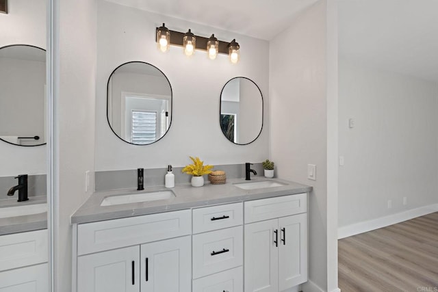 full bathroom featuring double vanity, a sink, and wood finished floors