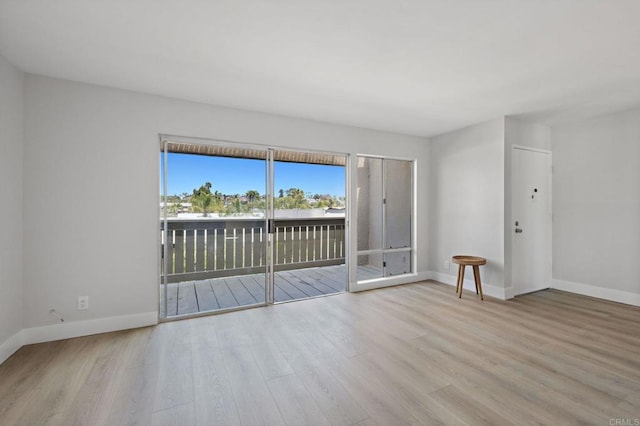 unfurnished room with baseboards and wood finished floors