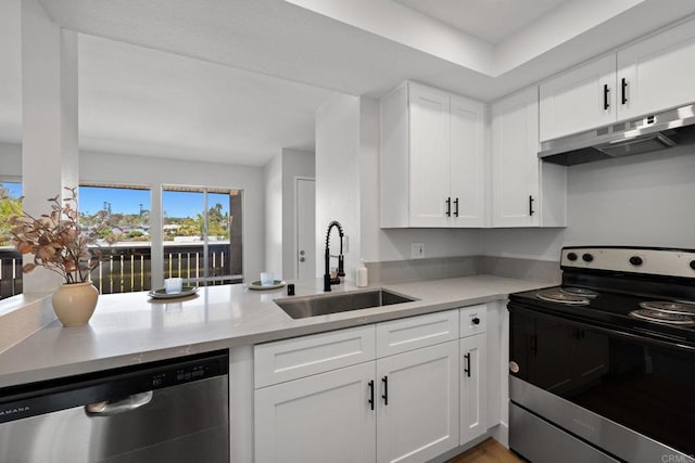 kitchen featuring appliances with stainless steel finishes, a sink, light countertops, under cabinet range hood, and white cabinetry