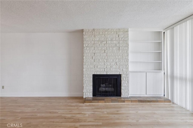 10966 Rochester Ave Unit 5D, Los Angeles, CA 90024 - interior details featuring a fireplace, a textured ceiling, and wood finished floors