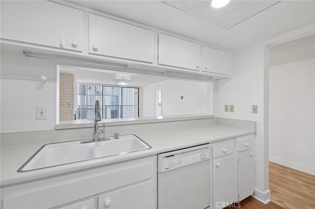 10966 Rochester Ave Unit 5D, Los Angeles, CA 90024 - kitchen with white cabinets, a sink, dishwasher, light countertops, and wood finished floors