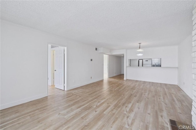 10966 Rochester Ave Unit 5D, Los Angeles, CA 90024 - unfurnished living room featuring light wood-style floors and a textured ceiling