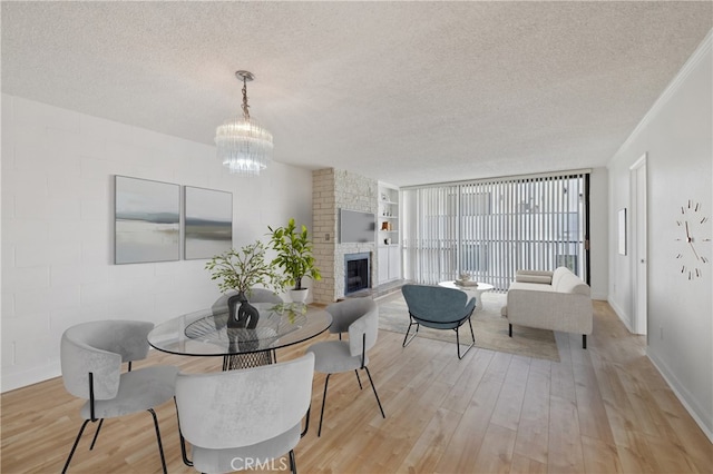 10966 Rochester Ave Unit 5D, Los Angeles, CA 90024 - dining space featuring a textured ceiling, a chandelier, and light wood-type flooring