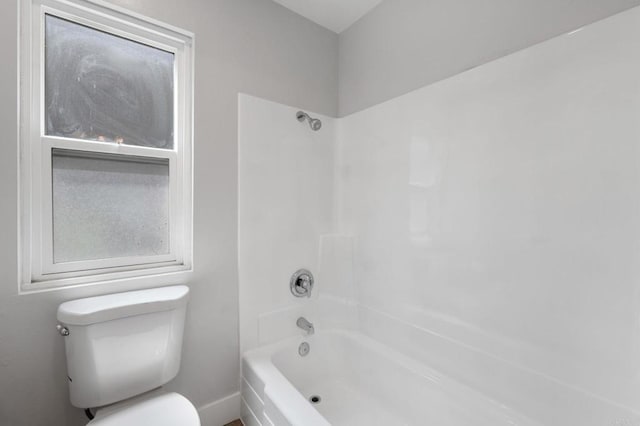 bathroom featuring shower / bath combination, baseboards, and toilet