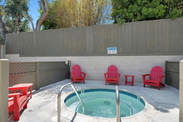 view of pool featuring a hot tub, fence, and a patio area
