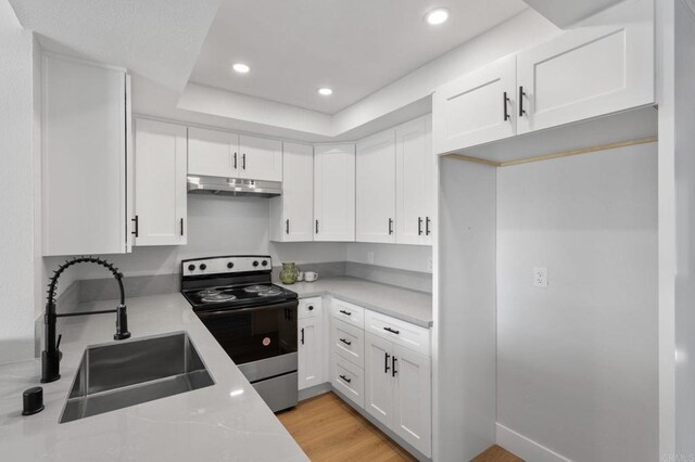 149 W Glaucus St Unit D, Encinitas, CA 92024 - kitchen with stainless steel electric range, under cabinet range hood, white cabinetry, light countertops, and recessed lighting