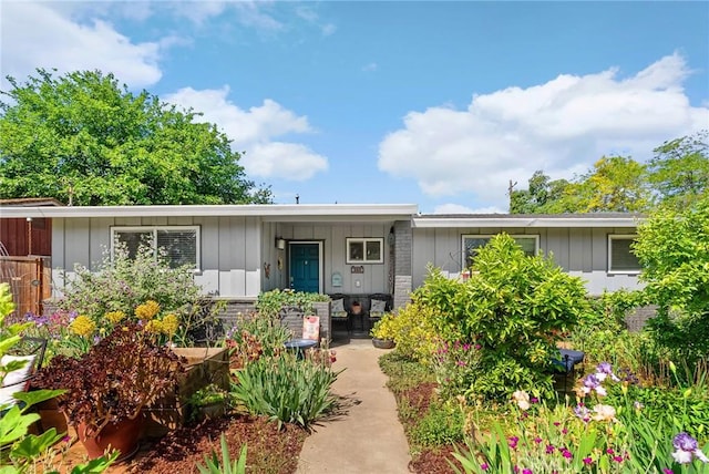 ranch-style home featuring board and batten siding and covered porch