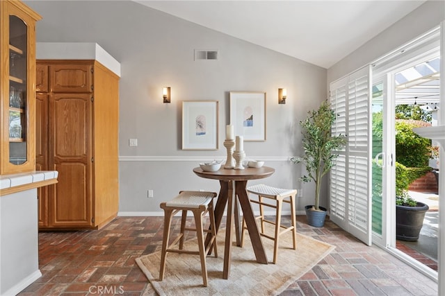 3 Treethorne Cir, Laguna Niguel, CA 92677 - dining area featuring visible vents, baseboards, brick floor, and lofted ceiling