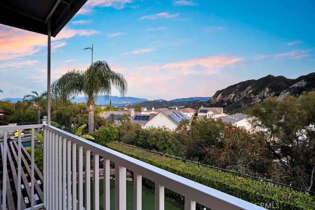 balcony at dusk featuring a mountain view