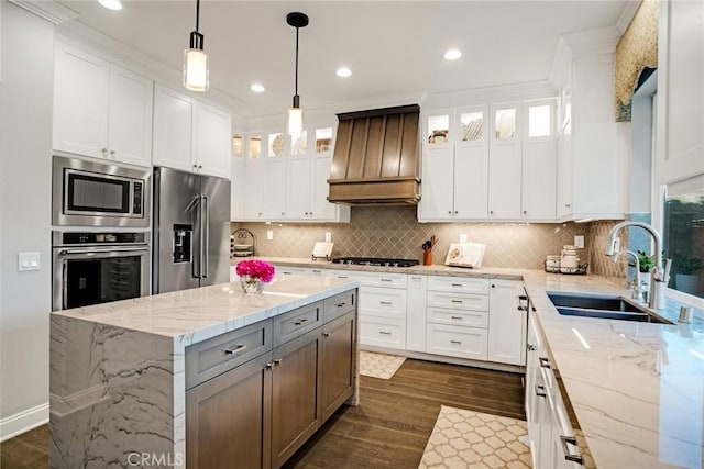 kitchen featuring dark wood finished floors, custom range hood, a sink, stainless steel appliances, and white cabinetry