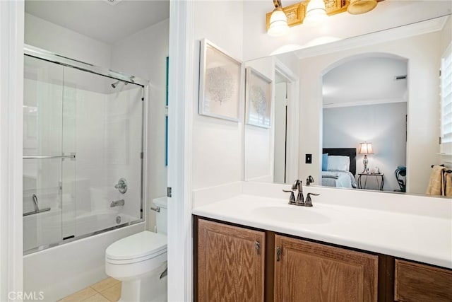 bathroom featuring vanity, crown molding, toilet, combined bath / shower with glass door, and ensuite bath