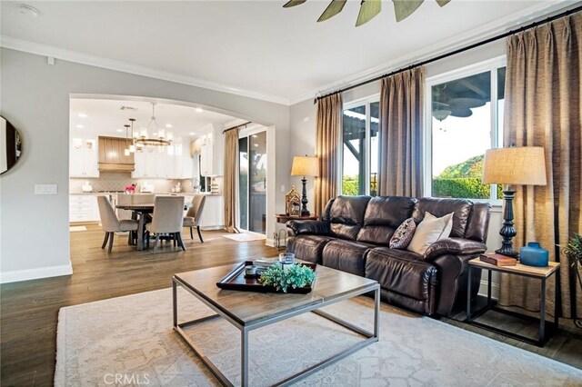 26238 Beecher Ln, Stevenson Ranch, CA 91381 - living room with wood finished floors, ornamental molding, arched walkways, a chandelier, and recessed lighting