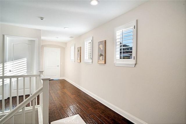 corridor featuring a healthy amount of sunlight, baseboards, recessed lighting, and dark wood-style floors